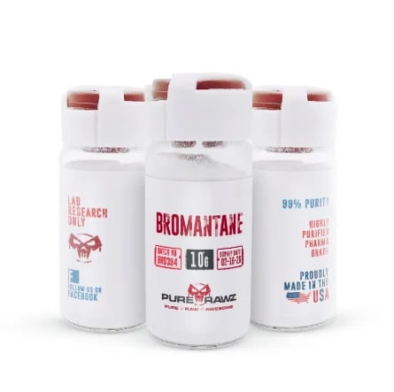 Three white canisters of bromantane powder displayed in a group arrangement with red caps
